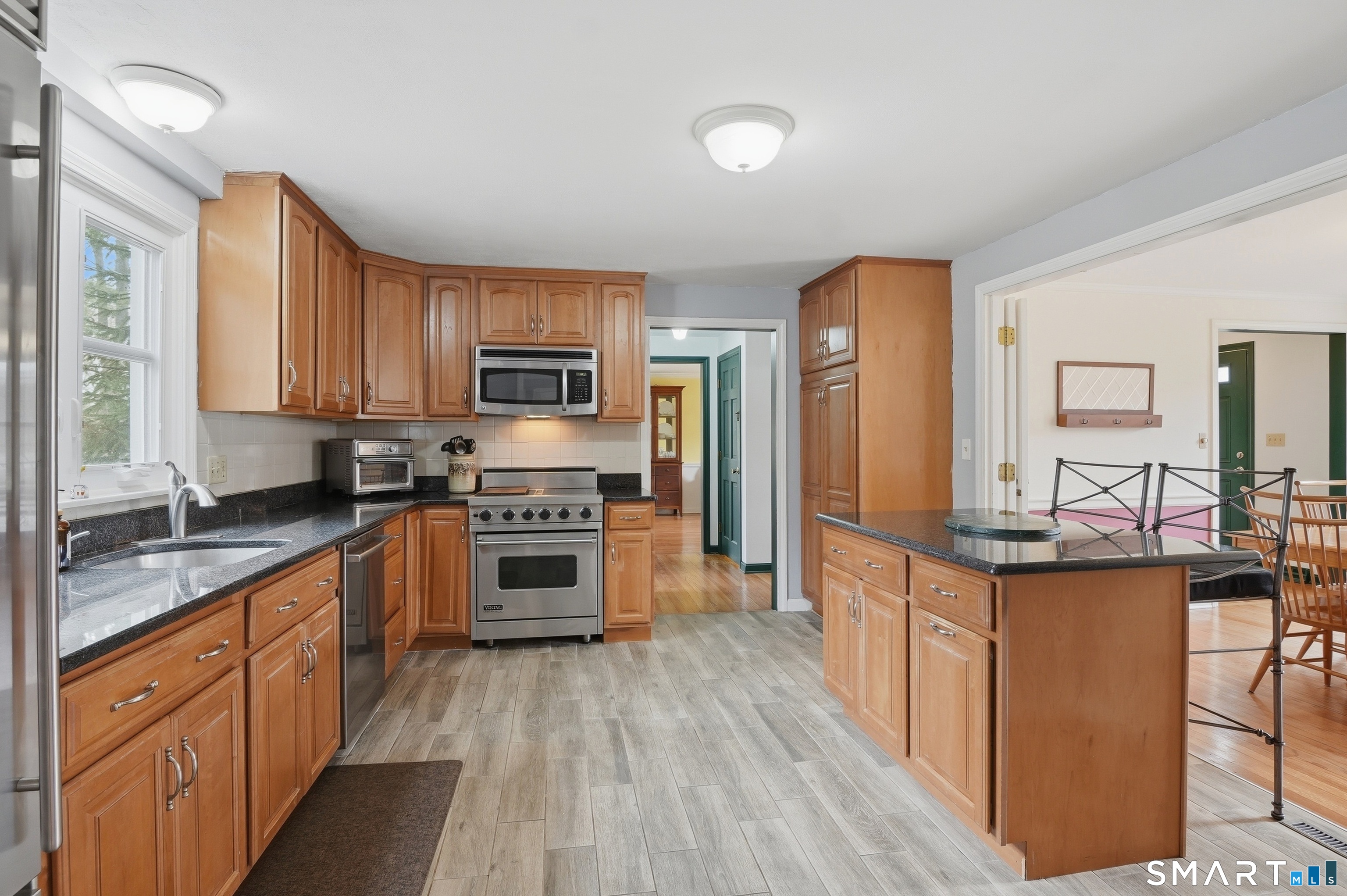 88 Nob Hill Road Cheshire, CT 06410 - Photo 14 of 40 a kitchen with stainless steel appliances a stove top oven a sink a refrigerator white cabinets and wooden floor