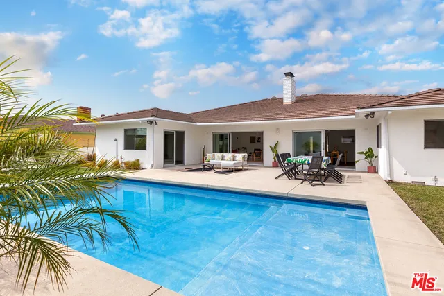 a view of a house with swimming pool and sitting area