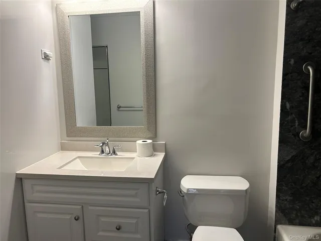a bathroom with a toilet sink and mirror