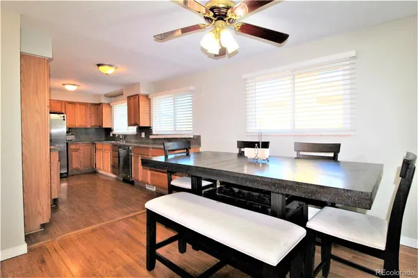 a kitchen with stainless steel appliances a table chairs and a refrigerator