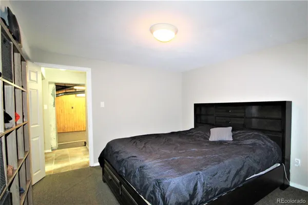 a bedroom with a bed and a potted plant on the dresser