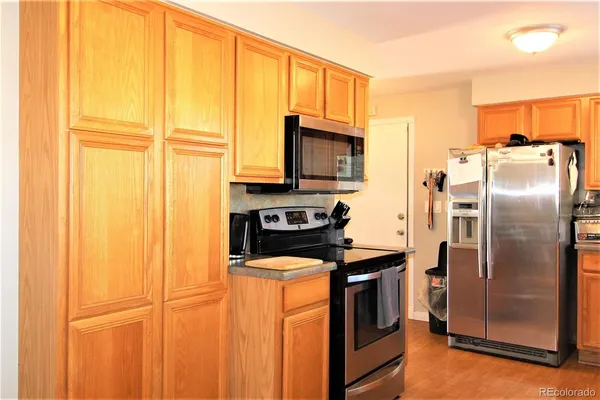 a kitchen with stainless steel appliances granite countertop a refrigerator a stove and a sink