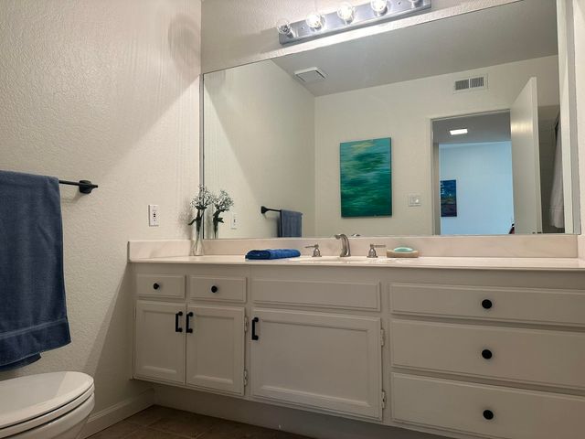 a bathroom with a double vanity sink toilet mirror and bathtub