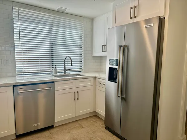 a kitchen with stainless steel appliances a refrigerator sink and cabinets