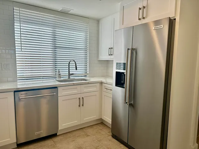 a kitchen with stainless steel appliances a refrigerator sink and cabinets
