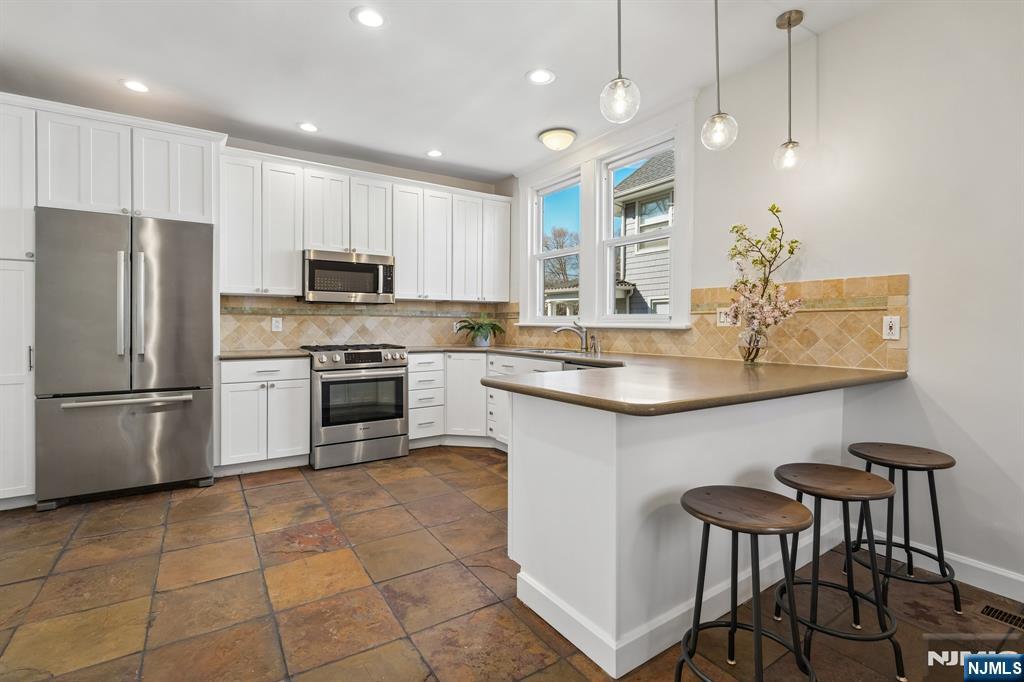 115 Park Street Montclair, NJ 07042 - Photo 21 of 45 a kitchen with a sink a refrigerator and white cabinets
