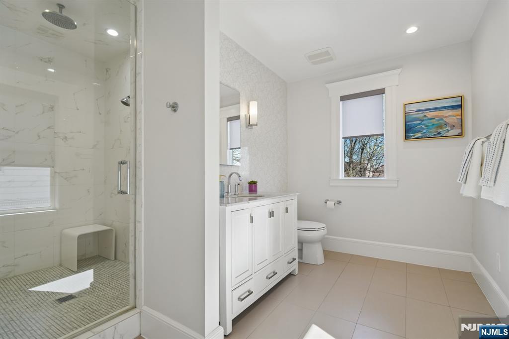 115 Park Street Montclair, NJ 07042 - Photo 29 of 45 a spacious bathroom with a toilet a sink and a mirror