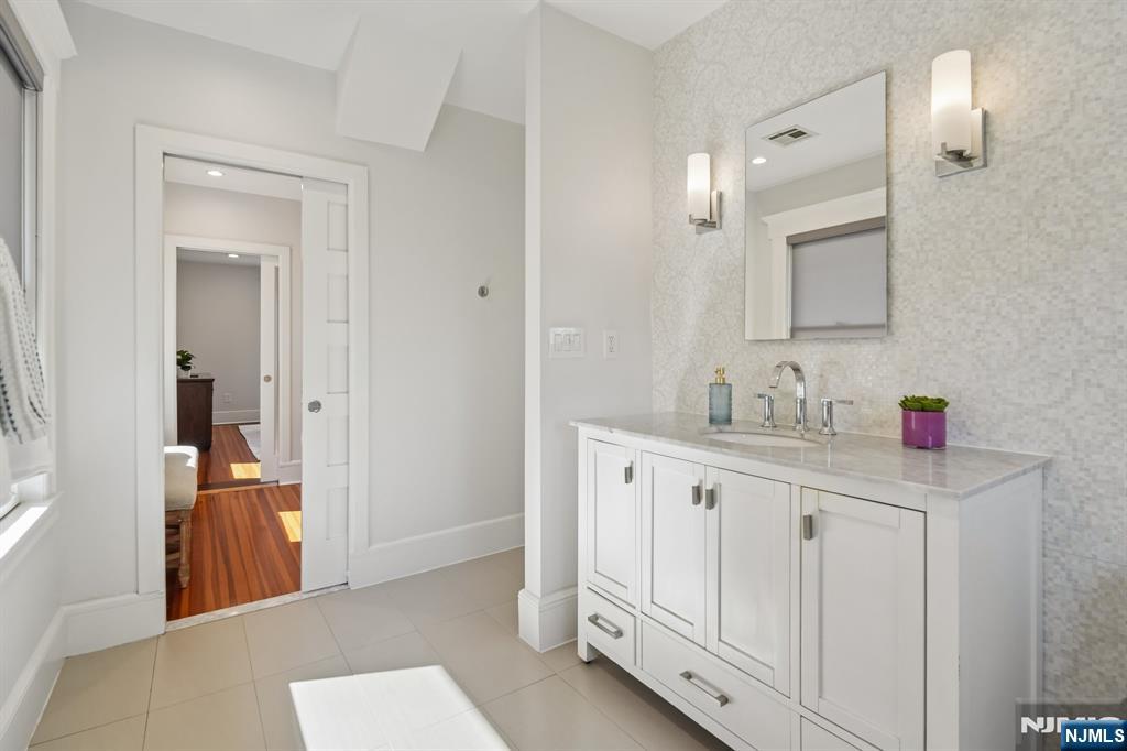115 Park Street Montclair, NJ 07042 - Photo 30 of 45 a bathroom with double sink and a mirror
