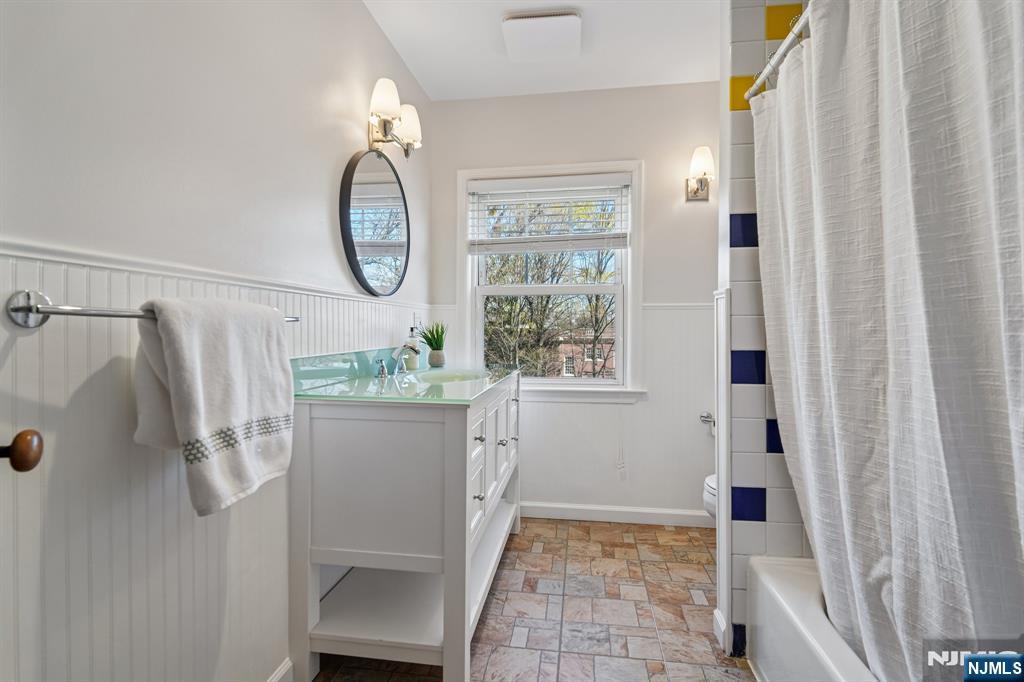 115 Park Street Montclair, NJ 07042 - Photo 37 of 45 a bathroom with a granite countertop shower a sink and a mirror