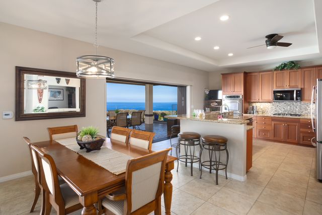 a view of a dining room with furniture a kitchen and chandelier