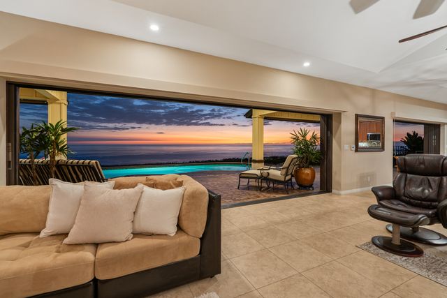 a living room with furniture a rug and a floor to ceiling window