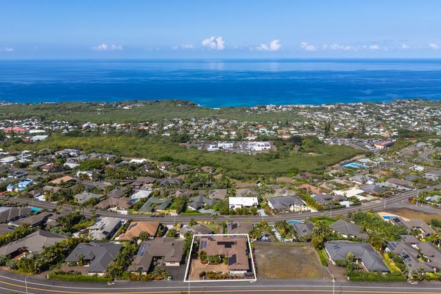 an aerial view of ocean and residential houses with outdoor space
