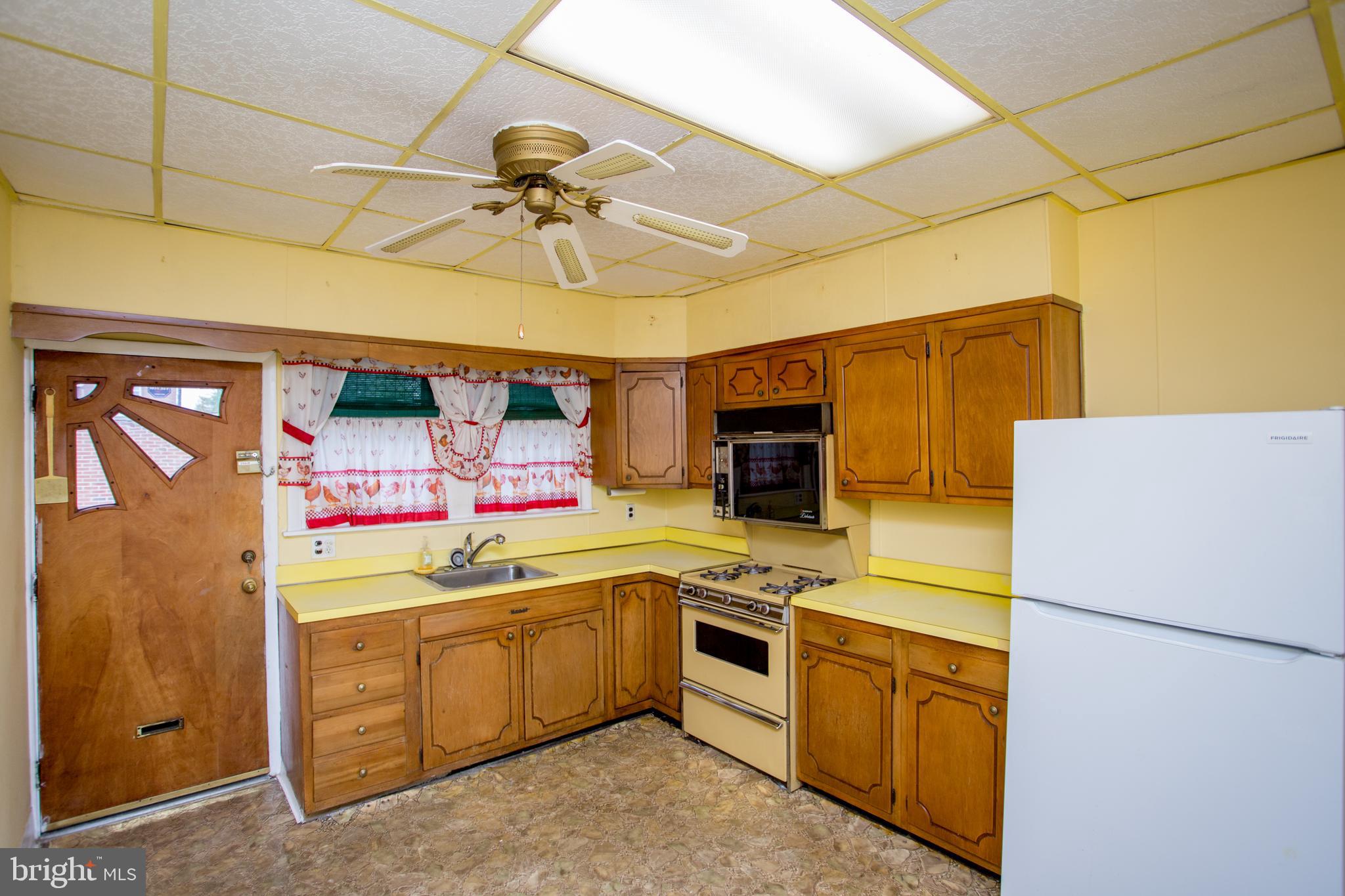 2116 North Natrona Street Philadelphia, PA 19121 - Photo 14 of 53 a kitchen with a sink a refrigerator and cabinets