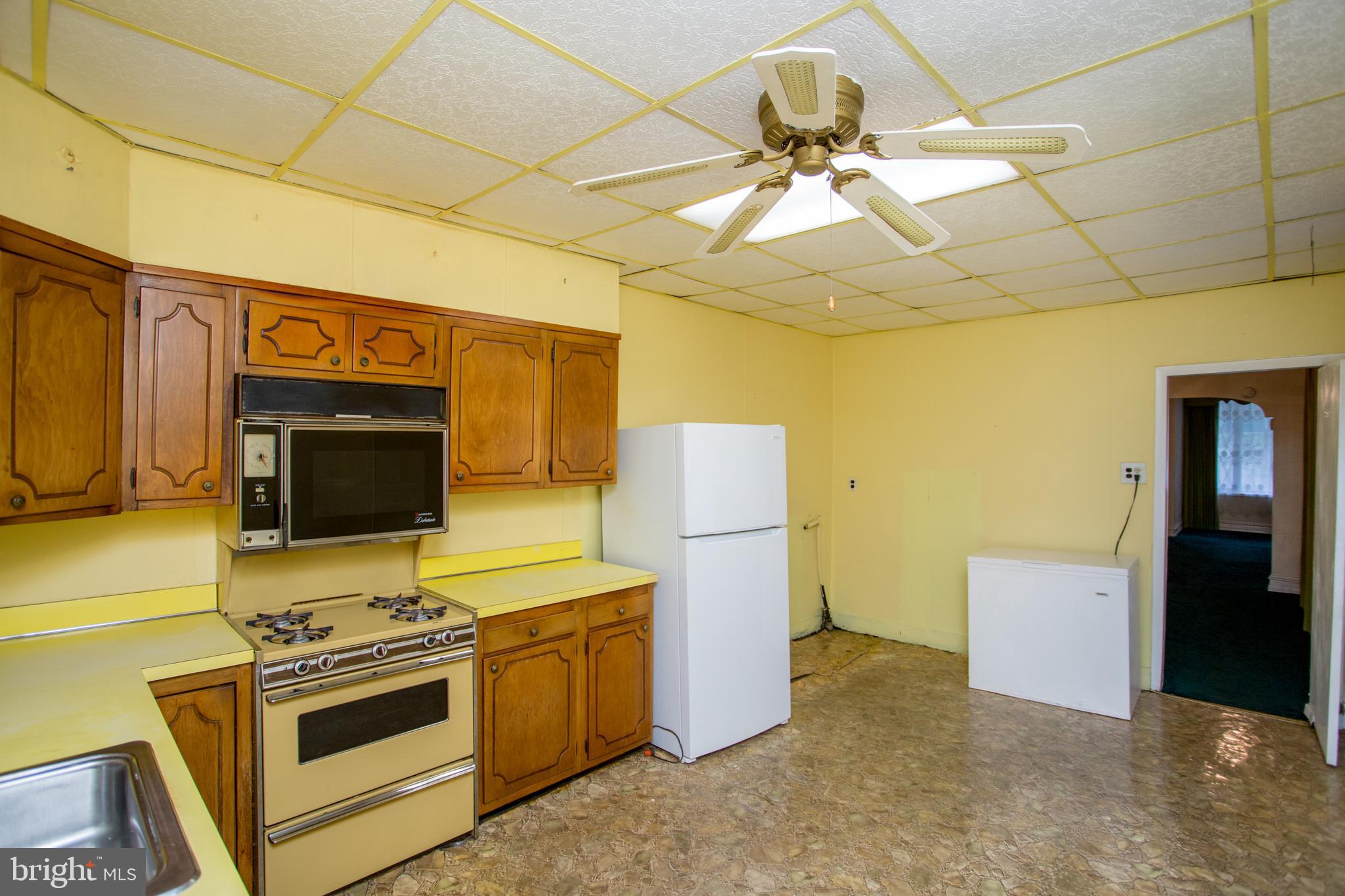 2116 North Natrona Street Philadelphia, PA 19121 - Photo 17 of 53 a kitchen with a refrigerator and a stove top oven