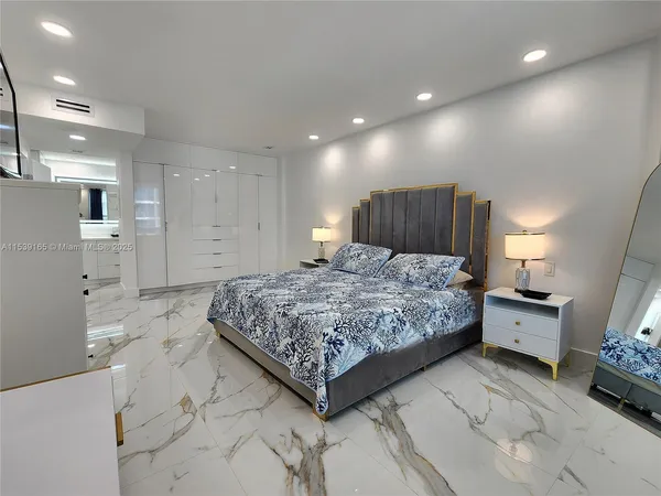 a large bedroom with a bed and a view of living room