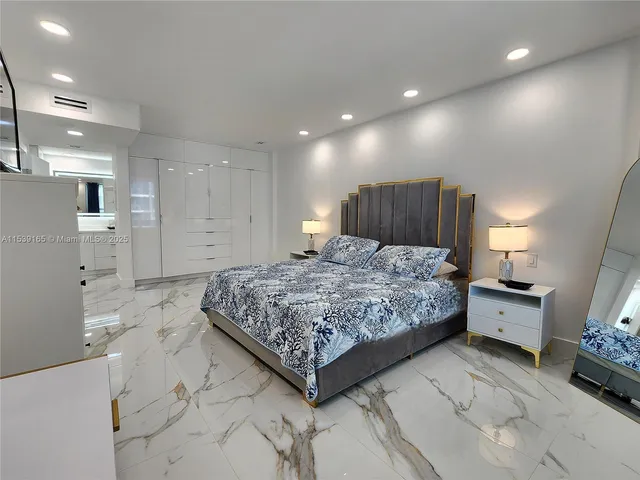 a large bedroom with a bed and a view of living room