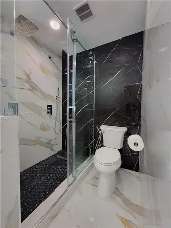 a bathroom with a toilet and a shower