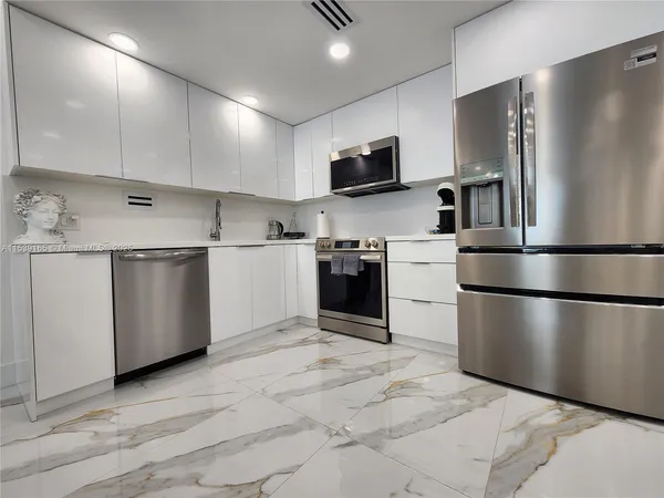 a kitchen with stainless steel appliances granite countertop a refrigerator stove a sink and a microwave