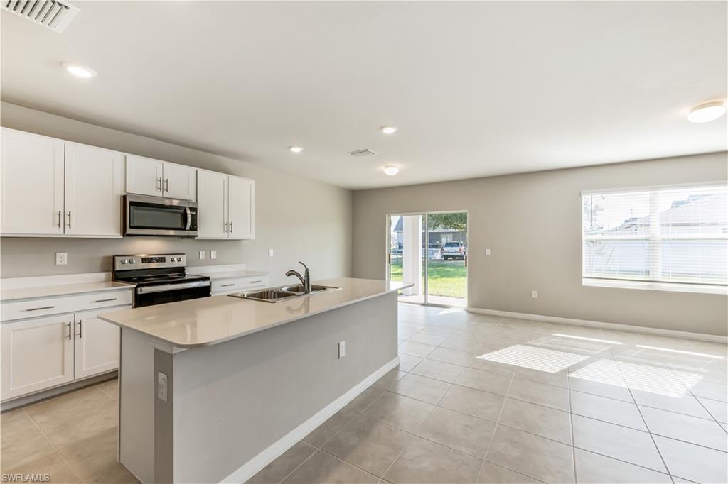17764 Shade Tree Loop Punta Gorda, FL 33982 - Photo 6 of 48 a kitchen with a sink a window and stainless steel appliances