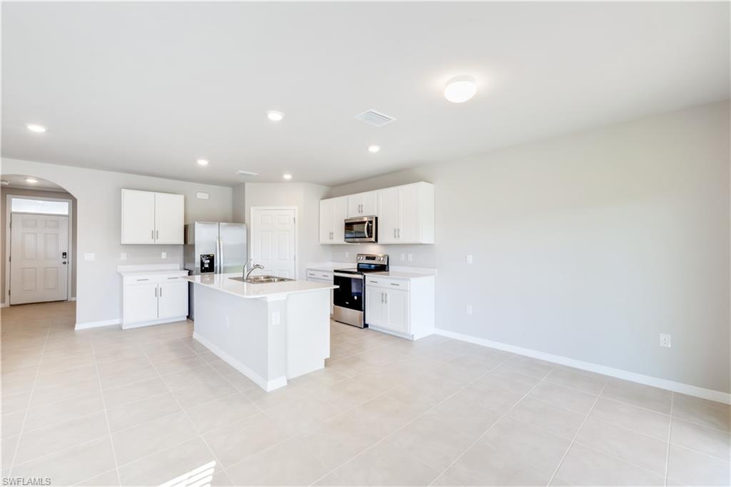 17764 Shade Tree Loop Punta Gorda, FL 33982 - Photo 8 of 48 a large white kitchen with cabinets and a refrigerator