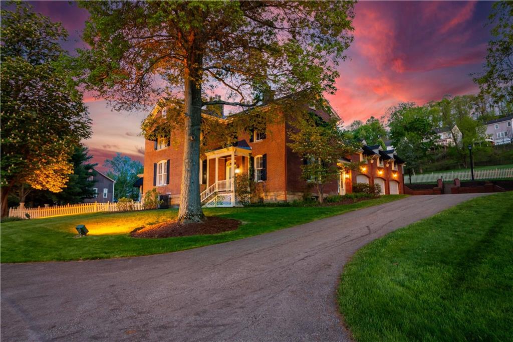 A breathtaking twilight view of this Washington County landmark. The warm interior glow spills onto the manicured lawn, highlighting the majestic brick architecture and the iconic wrap-around porch. Framed by mature trees against a vibrant sunset sky, this elevation perfectly showcases the estate’s private and commanding presence. Enjoy the prestige of a landmark estate with the added benefit of Clean and Green real estate tax status on 14 private acres.