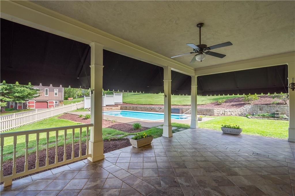 571 West McMurray Road Canonsburg, PA 15317 - Photo 37 of 47 Enjoy seamless indoor-outdoor living on this spacious, covered wrap-around patio. Featuring elegant tile flooring, a cooling ceiling fan, and retractable sunshades, it offers a perfect vantage point overlooking the pristine in-ground pool and lush acreage