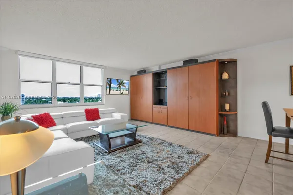 a living room with rug floor to ceiling window and couch