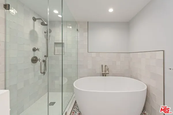 a white bath tub sitting next to a shower