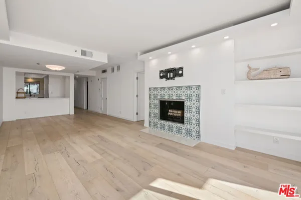 a view of empty room with wooden floor and fireplace