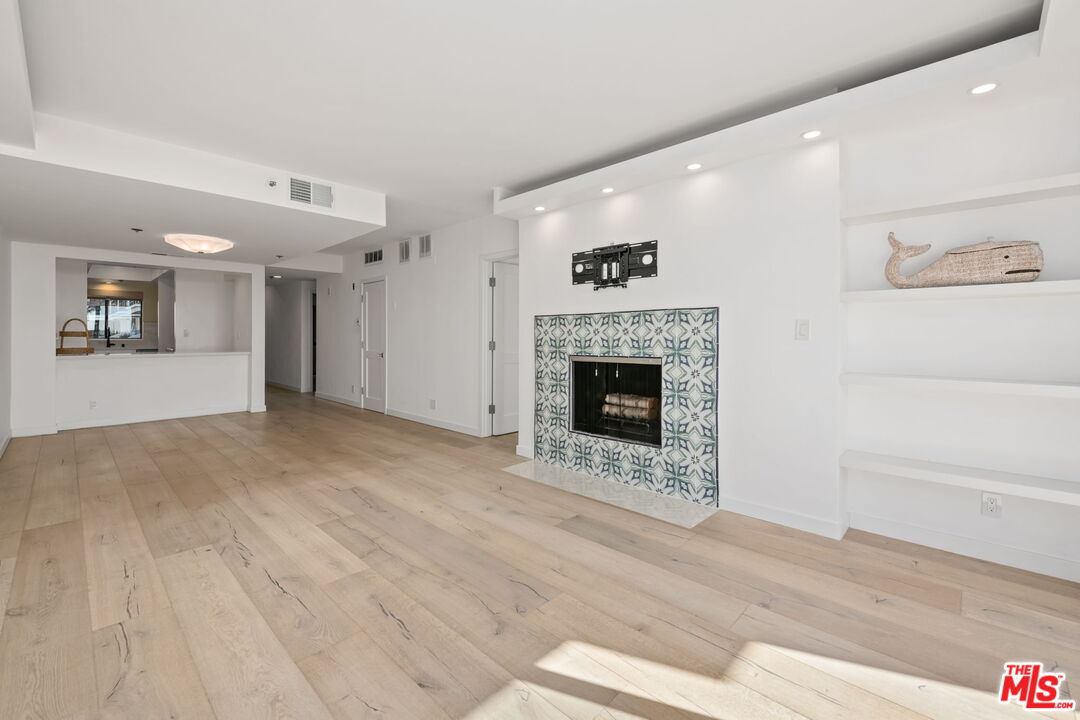 2920 Neilson Way, Unit 303 Santa Monica, CA 90405 - Photo 2 of 34 a view of empty room with wooden floor and fireplace