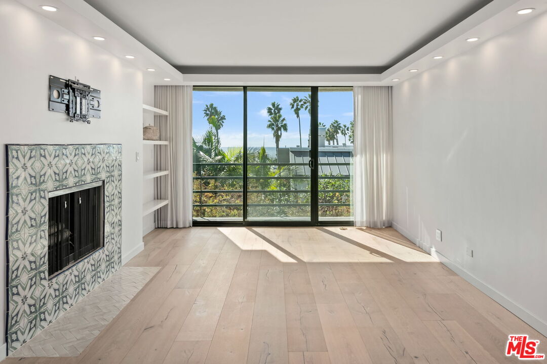 2920 Neilson Way, Unit 303 Santa Monica, CA 90405 - Photo 4 of 34 a view of an empty room with windows and a fireplace