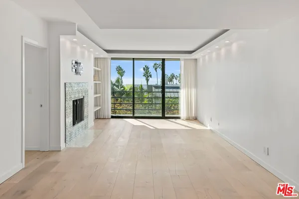 a view of a big room with windows and chandelier