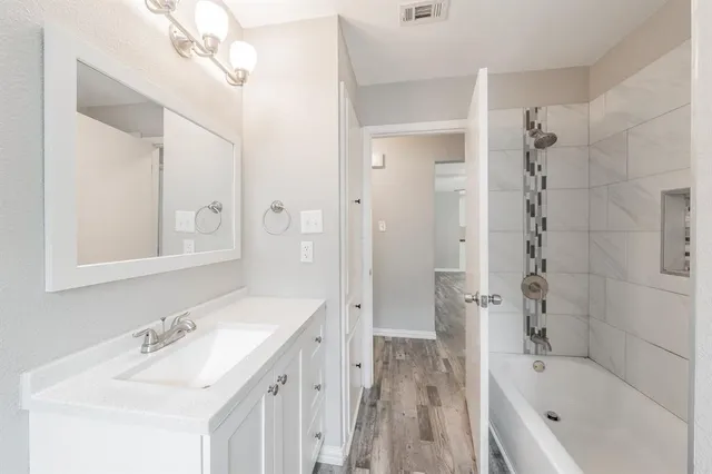 a bathroom with a tub sink shower and mirror