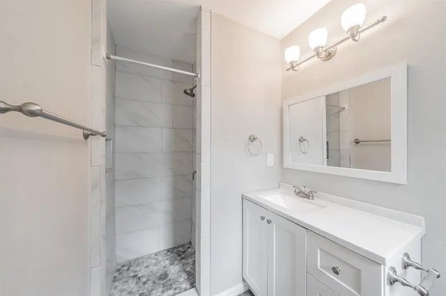 a bathroom with a granite countertop toilet a sink a mirror and a window