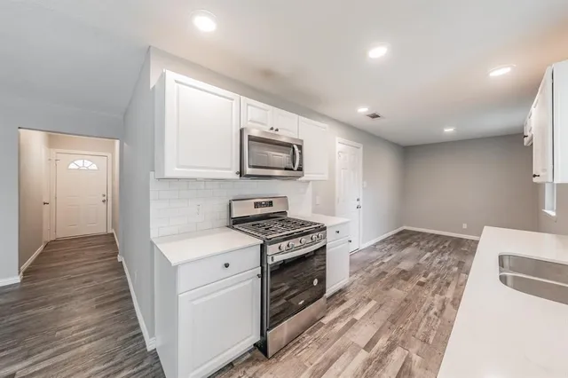 a kitchen with a stove a sink and a microwave