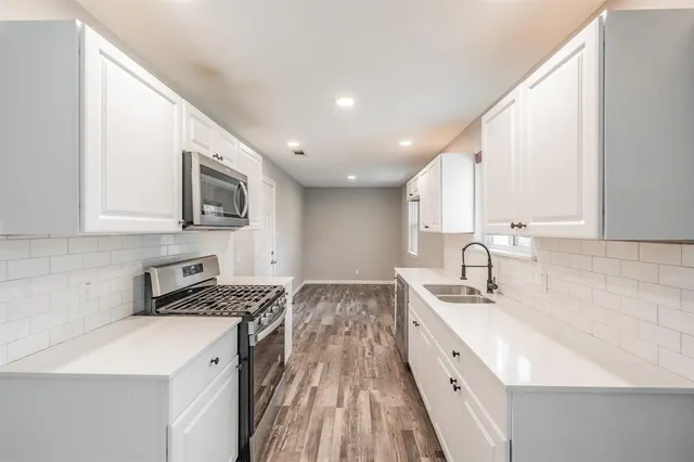 a kitchen with granite countertop a sink a stove and cabinets