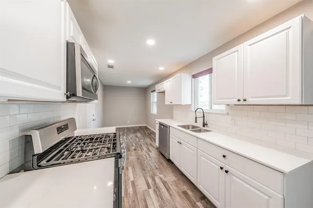 a kitchen with a sink stove and cabinets
