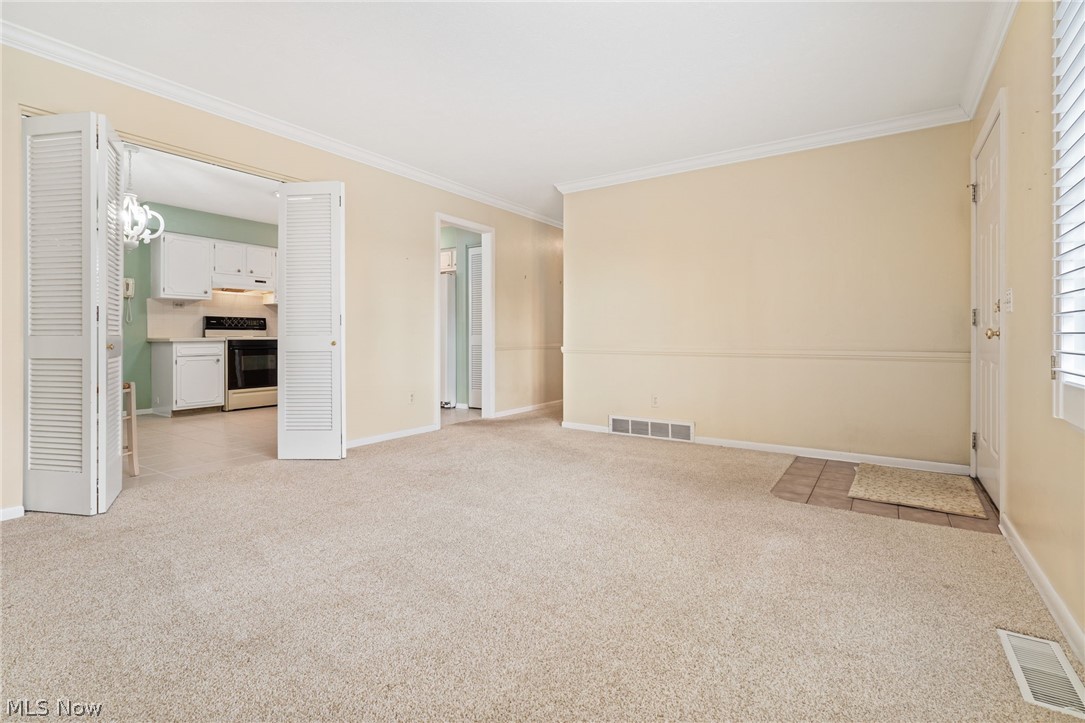 271 Manor Avenue Northwest Canton, OH 44708 - Photo 5 of 26 Unfurnished living room with ornamental molding and light colored carpet