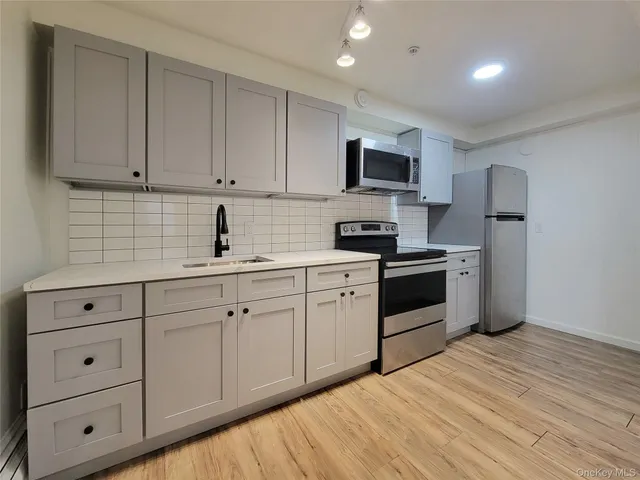 a kitchen with white cabinets stainless steel appliances and sink