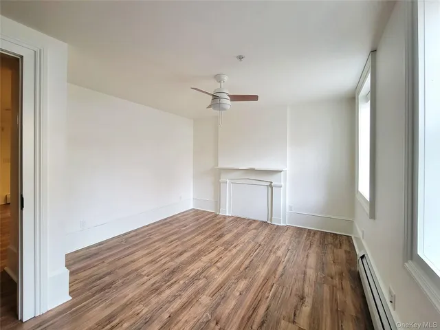 a view of a room with wooden floor and a ceiling fan