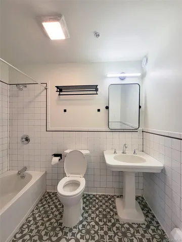 a bathroom with a sink toilet a mirror and bathtub