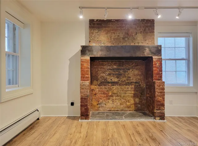 a view of a hallway with wooden floor and a fireplace