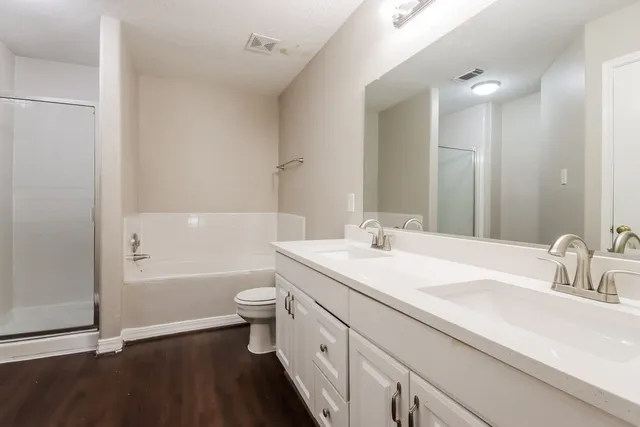 a bathroom with a double vanity sink toilet and shower