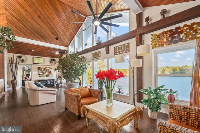 a kitchen with stainless steel appliances granite countertop a stove top oven a sink a dining table and chairs with wooden floor