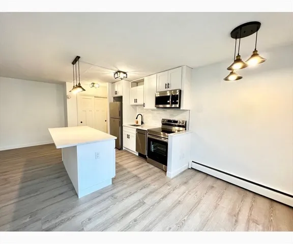 a kitchen with stainless steel appliances a refrigerator and a stove top oven