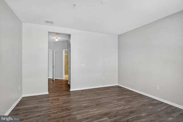 a view of an empty room with wooden floor