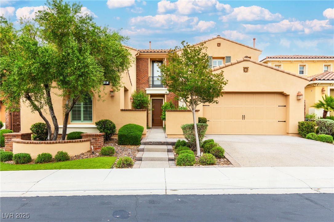 58 Contrada Fiore Drive Henderson, NV 89011 - Photo 4 of 56 Mediterranean / spanish-style home featuring a garage, driveway, stucco siding, a balcony, and a tiled roof