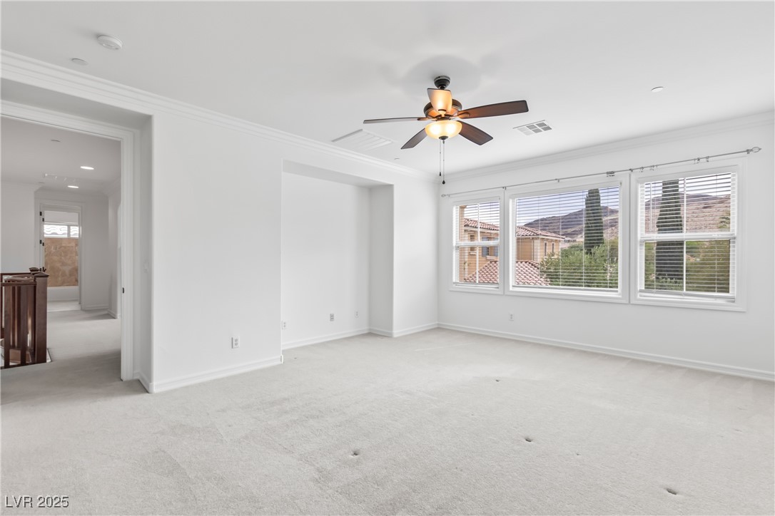 58 Contrada Fiore Drive Henderson, NV 89011 - Photo 42 of 56 Unfurnished room featuring crown molding, light colored carpet, and a ceiling fan