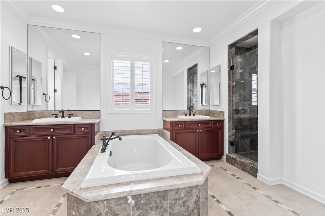 58 Contrada Fiore Drive Henderson, NV 89011 - Photo 45 of 56 Bathroom with inlaid floor details, ornamental molding, a shower stall, two vanities, and a bath