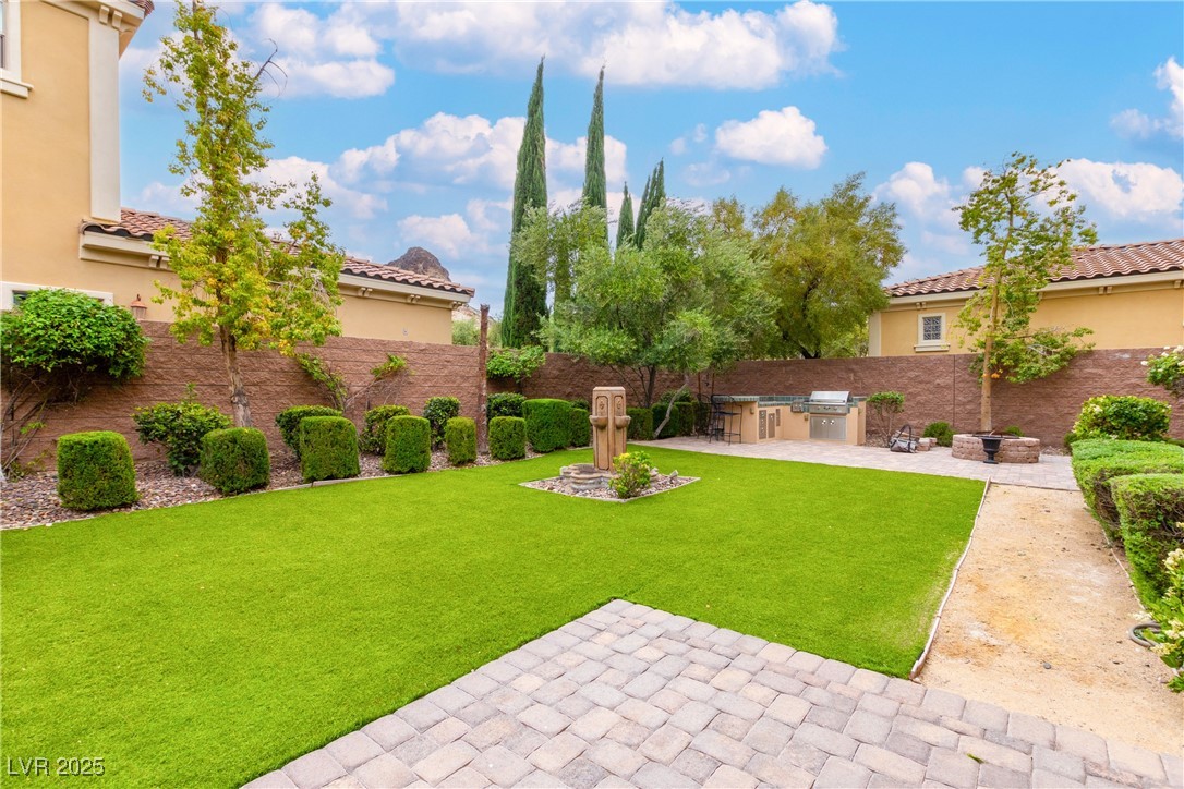 58 Contrada Fiore Drive Henderson, NV 89011 - Photo 50 of 56 Fenced backyard with exterior kitchen, a patio, and an outdoor fire pit